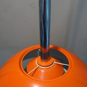 May include: A bright orange, dome-shaped pendant light fixture with a chrome metal hanging rod.