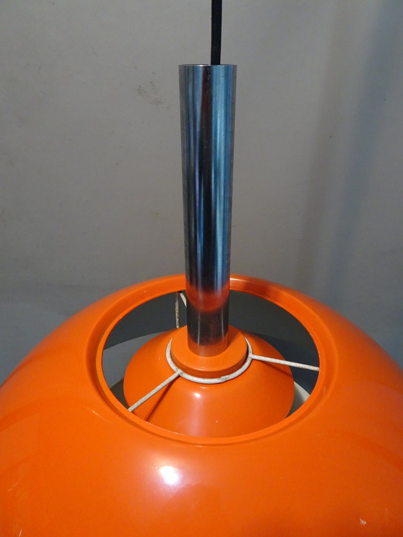 May include: A bright orange, dome-shaped pendant light fixture with a chrome metal hanging rod.
