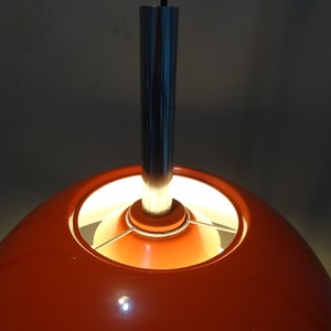 May include: Orange and silver pendant light with a round, orange shade and a silver metal rod.