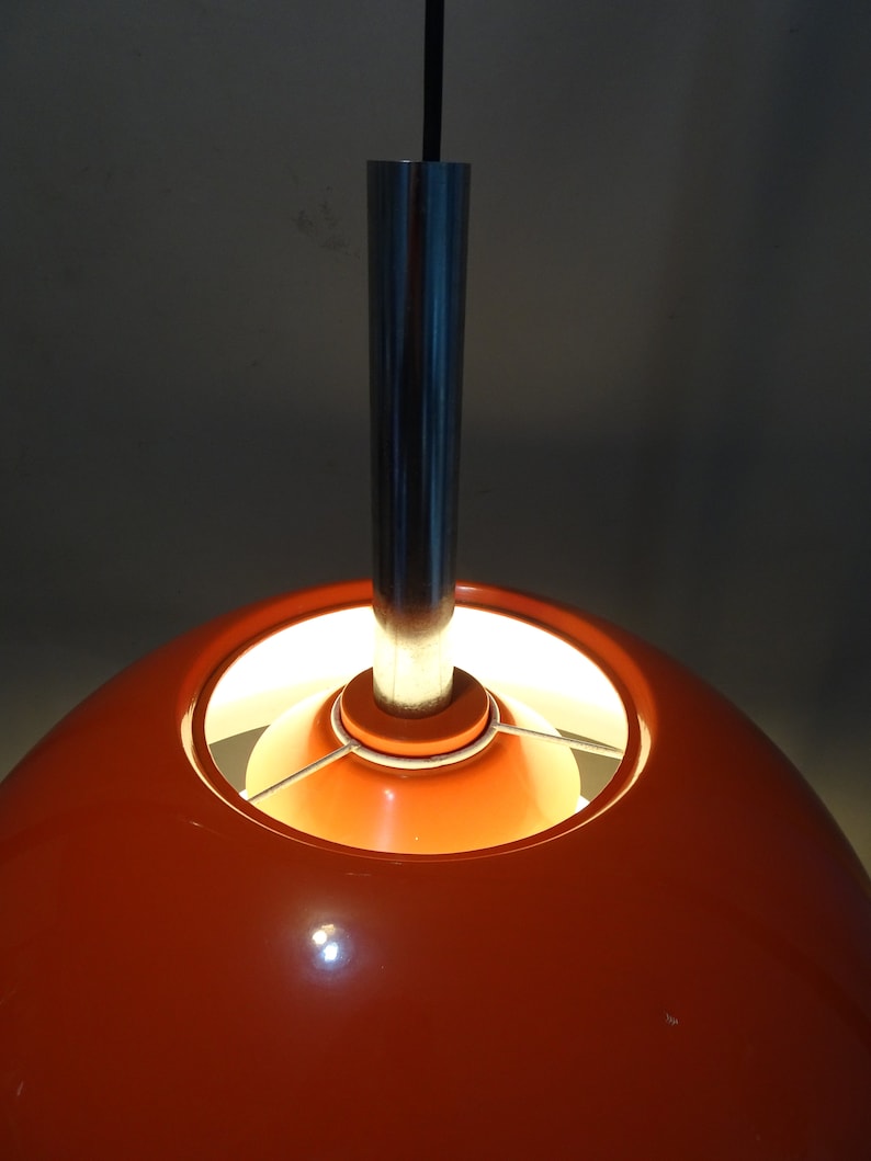May include: Orange and silver pendant light with a round, orange shade and a silver metal rod.