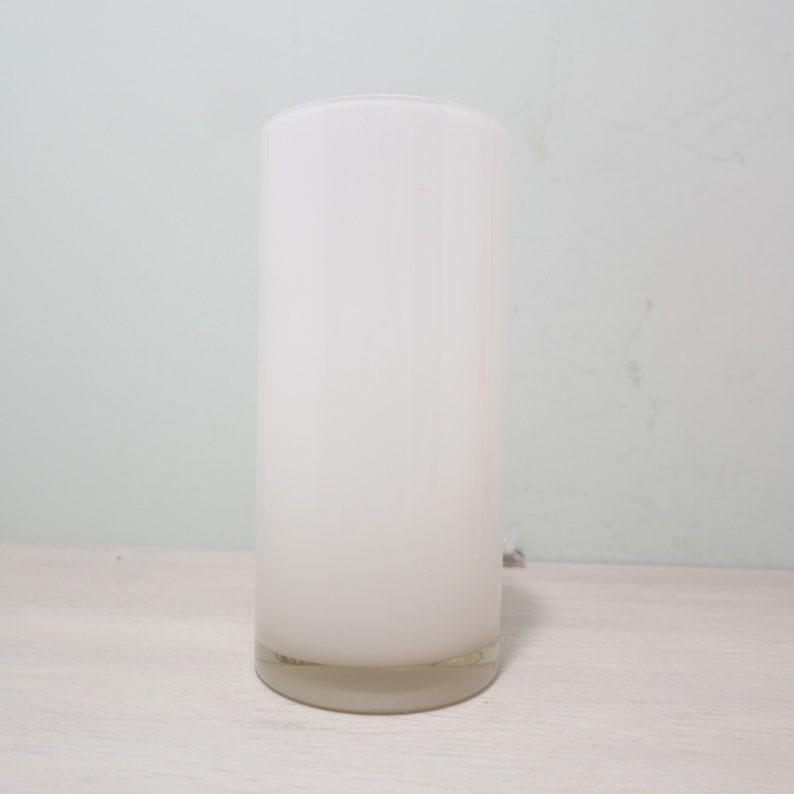 K&ouml;nnte beinhalten: Eine wei&szlig;e, gefrostete Glaszylindervase mit einem klaren Glasfu&szlig;.