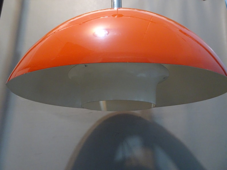 May include: Orange and white pendant light fixture with a dome-shaped shade.