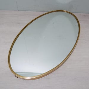 Peut inclure: Un miroir ovale avec un cadre en métal doré. La surface réfléchissante du miroir est claire et le cadre a une finition lisse et polie. Le miroir est conçu pour être fixé au mur et ajoute une touche d'élégance à n'importe quelle pièce.