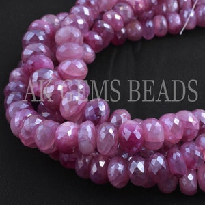 May include: A strand of pink faceted gemstone beads. The beads are round and have a smooth, polished finish.  AK Gems Beads.