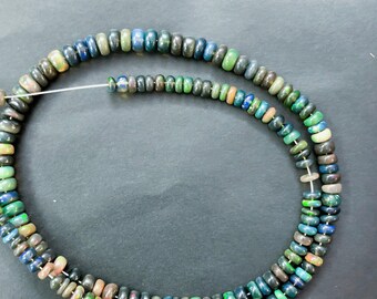 May include: A strand of dark blue, green, and brown opal beads. The beads are round and have a smooth, polished finish.