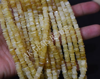 May include: A strand of yellow and white opal beads, each bead is square shaped and approximately 6mm in size. The beads are strung on a clear elastic cord. The strand is approximately 18 inches long. AK Gems Beads is printed on the strand.