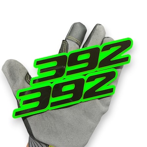 May include: Two black and green "392" decals are displayed on a grey work glove. The decals have a neon green outline and are angled across the glove. The glove is made of grey suede-like material.