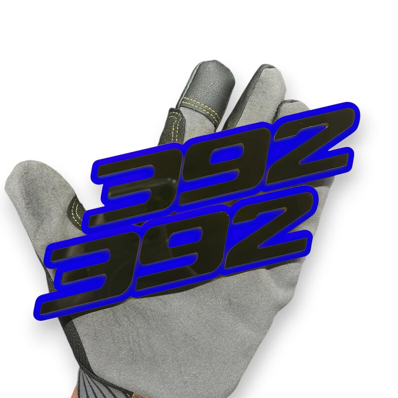 May include: A grey work glove with a black and blue graphic of the number "392" repeated three times. The glove has a reinforced leather palm and fingertips, with yellow stitching.