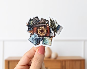 May include: A vintage camera with a compass face is surrounded by instant photos of nature scenes, including mountains, trees, and water.