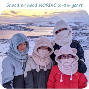 May include: Three children wearing fleece snoods or hoods with ear flaps. The snoods are in blue, pink, and beige. The children are standing in front of a snowy mountain landscape. The text "Snood or hood NORDIC 2-16 years" is at the top of the image.