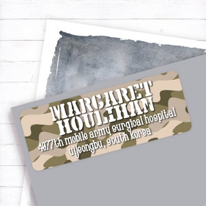 May include: A camouflage-patterned address label with the text "MARGARET HOULIHAN 4877th mobile army surgical hospital uijeongbu, south korea" in white.