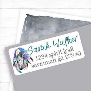 May include: A white return address label with a colorful illustration of a horse wearing a headdress. The text "Sarah Walker" is written in teal cursive. The address is "1234 spirit trail savannah ga 97840".
