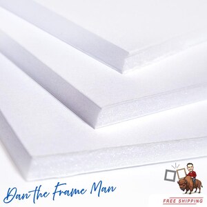 May include: Three white foam core boards stacked on top of each other. The boards are smooth and have a white, slightly textured surface. The boards are used for framing and mounting artwork.
