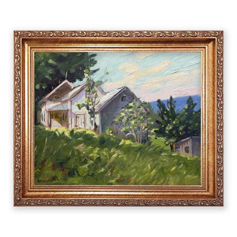 May include: Oil painting of a rural landscape featuring a white house with a gray roof, surrounded by green trees and tall grass. The artwork is framed in a gold-colored, ornate frame, adding a touch of elegance to the pastoral scene.