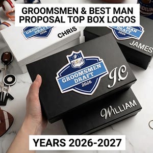 May include: Rectangular black and white gift boxes featuring a blue and white shield-shaped logo with the text GROOMSMEN DRAFT 2026. The boxes are personalized with silver lettering including the names CHRIS, JAMES, WILLIAM, and initials J.C.