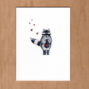 May include: A watercolor illustration of a raccoon holding a red heart in its paws. The raccoon is surrounded by small red hearts.