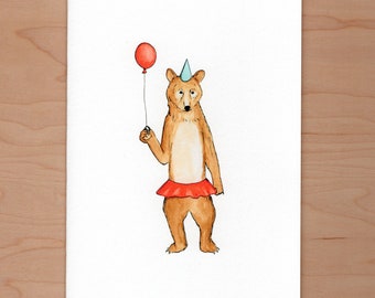 Puede incluir: Un oso marrón con un gorro de fiesta azul y una falda roja sostiene un globo rojo.