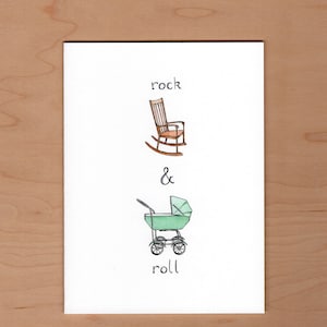 May include: A white card with a hand-drawn illustration of a rocking chair and a baby stroller. The text "rock & roll" is written below the illustration.