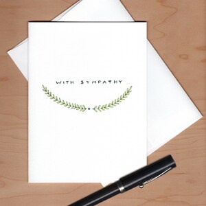 Card with envelope askew behind and a fountain pen below for scale