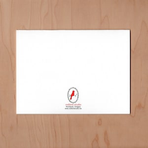 back of card has the redbird studio logo centered at the bottom. A red bird on a branch surround by an oval frame