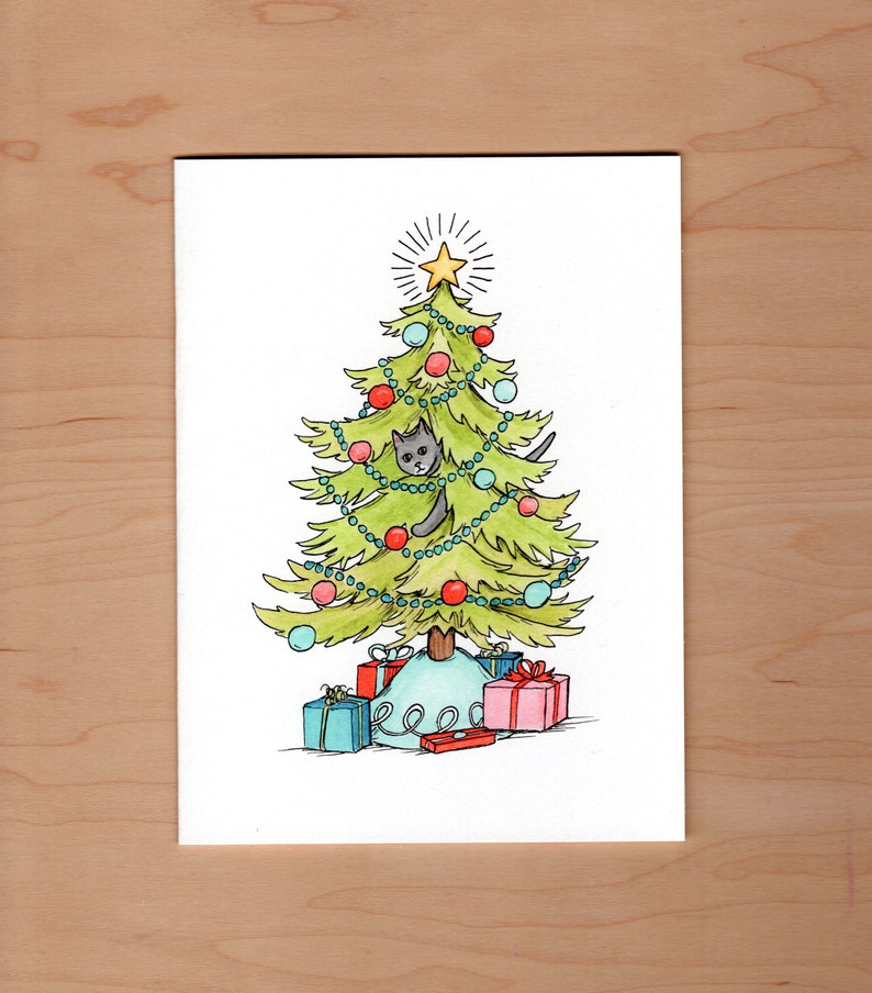 front of card: ink and watercolor illustration of a cheerfully decorated Christmas tree... a gray cat peeks out from the boughs to swat at an ornament