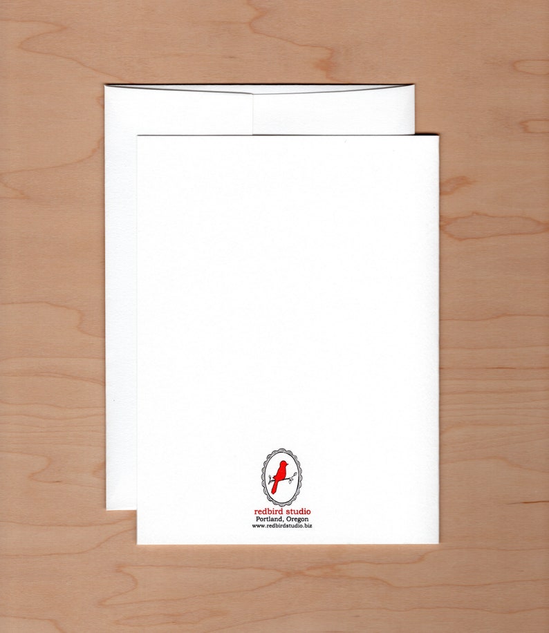 Pu&ograve; includere: Un set di biglietti di auguri e buste bianche. La carta presenta un logo di uccello rosso con il testo "redbird studio Portland, Oregon" in basso. Il set &egrave; su una superficie di legno marrone chiaro.