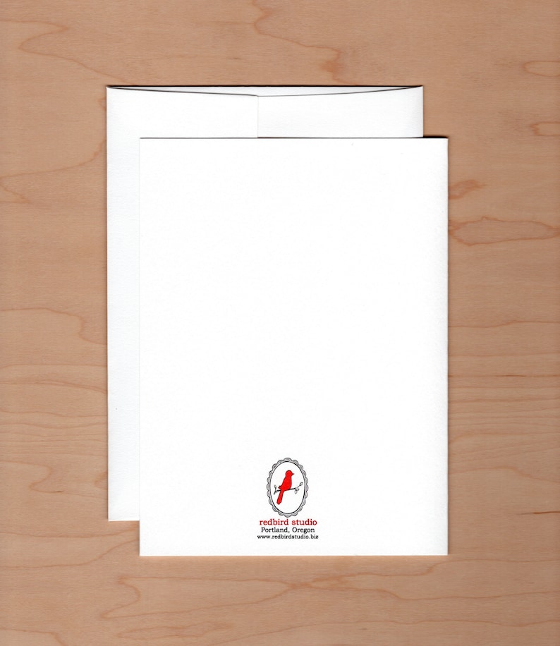 back of card showing logo of a redbird on a branch surrounded by an oval frame centered at the bottom