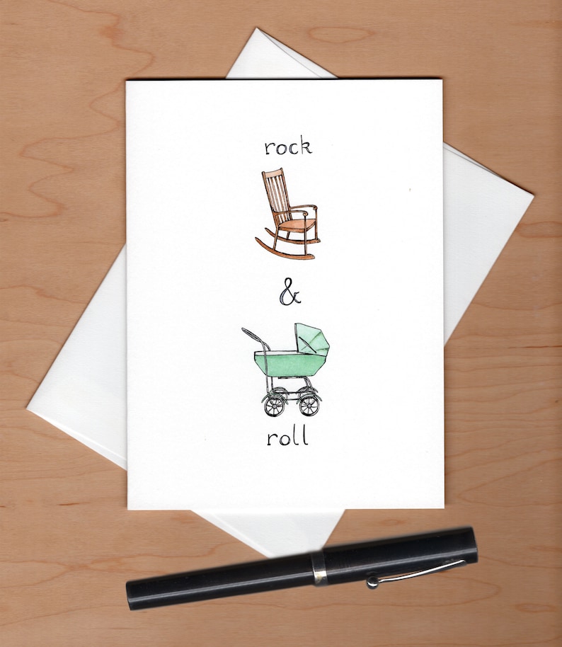 May include: A white card with a hand-drawn illustration of a rocking chair and a baby stroller. The text "rock & roll" is written below the illustrations.