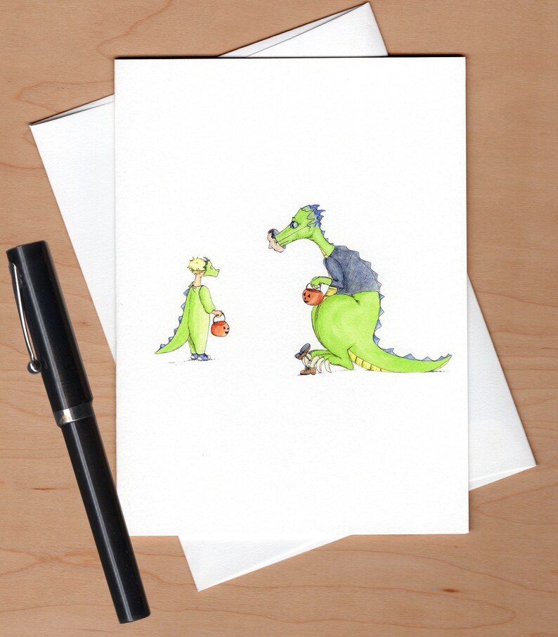 以下が含まれることがあります： ハロウィンで恐竜に扮した子供と親を描いた水彩画です。子供は小さなオレンジのバケツを持っており、親は大きなオレンジのバケツを持っています。どちらも緑色の恐竜の衣装を着ています。