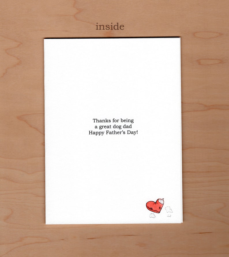 Pu&ograve; includere: Un biglietto di auguri bianco con la parola "inside" in alto. Il biglietto riporta il messaggio "Grazie per essere un grande pap&agrave; cane, buona festa del pap&agrave;!" e un'illustrazione di un cuore rosso con un morso.