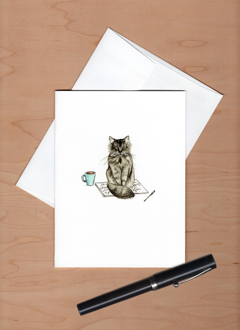 front of card with envelope askew behind and a black fountain pen below for scale