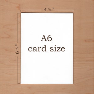 Peut inclure: Une carte blanche avec le texte "A6 card size" et des dimensions de 12,1 cm sur 15,9 cm.