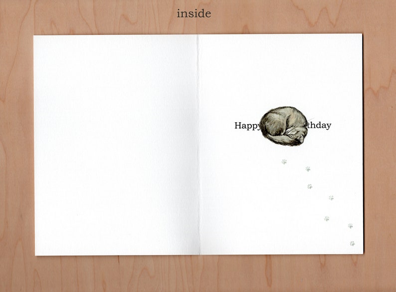inside of card;  the greeting would read happy birthday had the cat not wandered up leaving a row of paw prints then curling up in the middle of the words obscuring the greeting