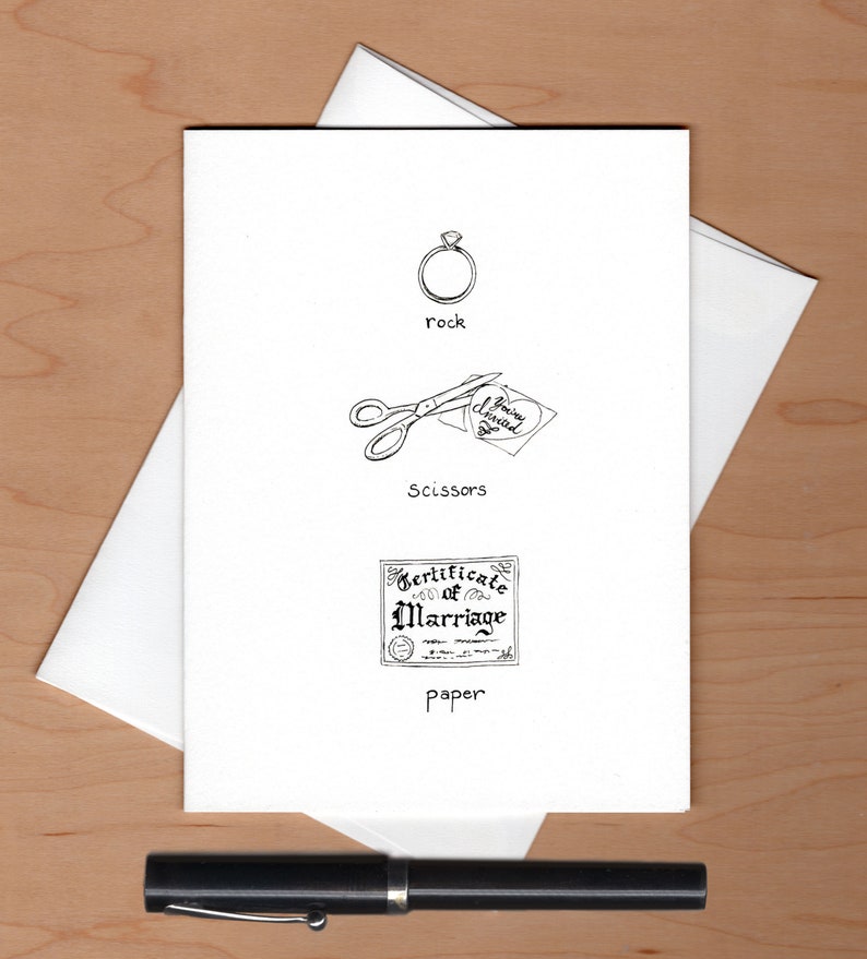 May include: A white card with a black and white illustration of a ring, scissors cutting a heart-shaped piece of paper with the text "You're Engaged", and a certificate of marriage. The text "rock", "scissors", and "paper" is written below each illustration.