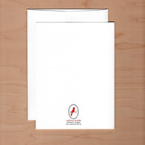 May include: A white card with a red bird logo in a circle. The text below the logo reads "redbird studio" "Portland, Oregon" "www.redbirdstudio.biz"