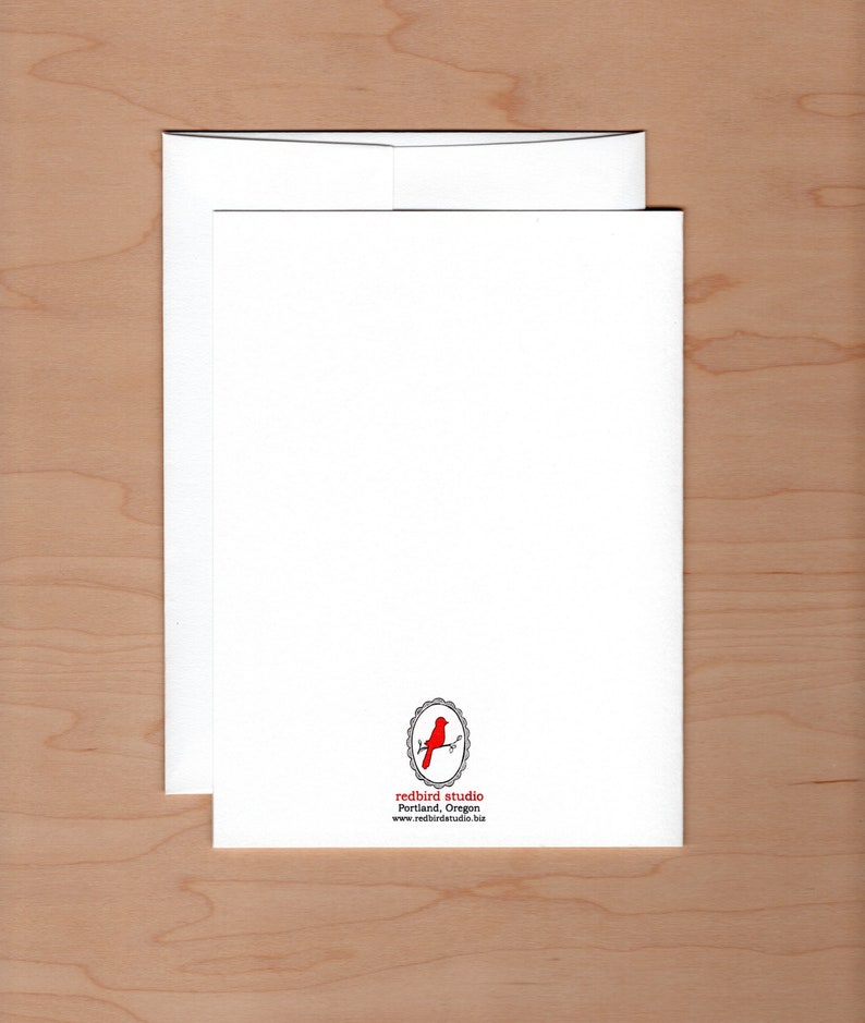 May include: A white card with a red bird logo in a circle. The text below the logo reads "redbird studio" "Portland, Oregon" "www.redbirdstudio.biz"