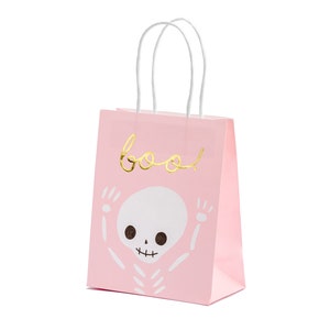 May include: Pink paper gift bag with white handles. The bag has a gold foil skeleton design and the word "boo!" in gold foil lettering.