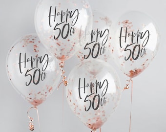 May include: Five clear balloons filled with rose gold confetti. Each balloon has the words "Happy 50th" printed in black script. The balloons are tied with rose gold ribbon and are suitable for a birthday celebration.