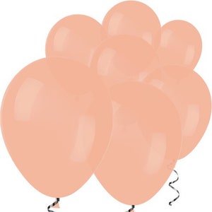 May include: A group of peach-colored latex balloons. The balloons are clustered together and appear to be inflated.
