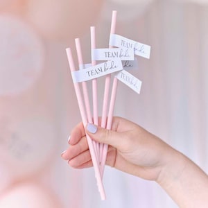May include: Pink paper straws with white labels that say "Team Bride" in black script.