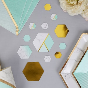 Op de afbeelding: Een set feestdecoraties met een marmer- en mintgroene kleurstelling. De decoraties omvatten papieren borden, servetten en confetti in de vorm van zeshoeken.