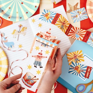 May include: A set of colourful circus-themed party supplies, including paper plates, paper streamers, and tickets that say "Admit One".