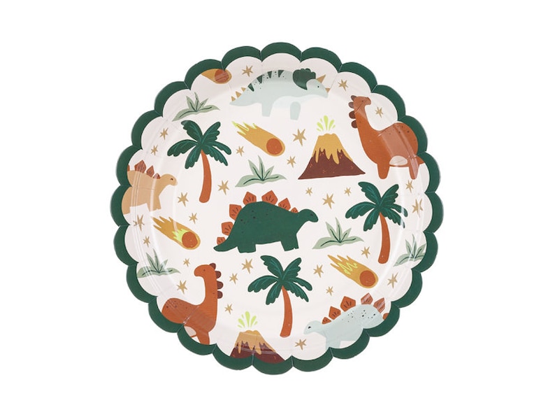 May include: A round paper plate with a scalloped green edge. The plate features a white background with a repeating pattern of cartoon dinosaurs, palm trees, volcanoes, and shooting stars in shades of green, brown, and orange.
