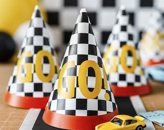 May include: Party hats with a black and white checkered pattern and the word "GO" in yellow. The hats have a red trim at the base. A yellow toy car sits on a black road graphic.