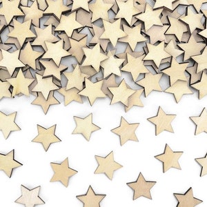 May include: A pile of wooden stars in a light brown colour, scattered on a white background. The stars are arranged in a random pattern, with some overlapping.