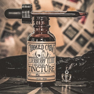 Op de afbeelding: Een bruine glazen fles met een druppelaar, met het label "Crooked Crows Elderberry Elixir Herbal Tincture No. 51 Handcrafted 1 fl oz - 29 ml".