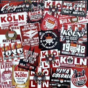 Könnte beinhalten: Eine Collage aus roten und weißen Aufklebern und Etiketten mit dem Wort "Köln" und dem Jahr "1948". Einige Aufkleber zeigen das Kölner Wappen, einen Doppeladler. Weitere Texte sind "Viva Colonia" und "Die Macht am Rhein".