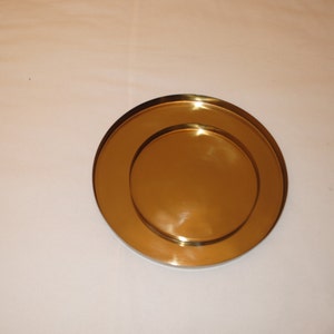 Pu&ograve; includere: Due piatti rotondi in metallo color oro, uno leggermente pi&ugrave; piccolo dell'altro, sono impilati uno sopra l'altro.
