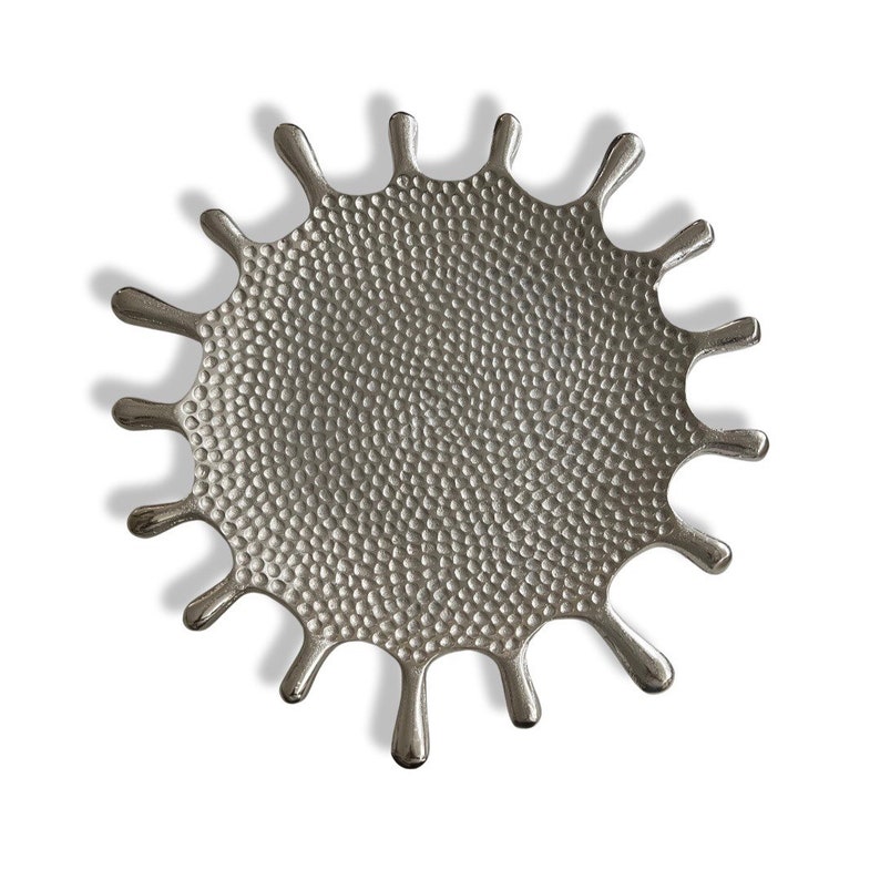 K&ouml;nnte beinhalten: Ein Tablett aus silbernem Metall in Form eines stilisierten Farbkleckses. Das Tablett hat eine strukturierte Oberfl&auml;che mit einer geh&auml;mmerten Oberfl&auml;che.