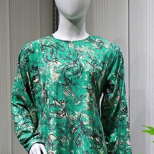May include: A green and white patterned long-sleeved dress with a round neckline.